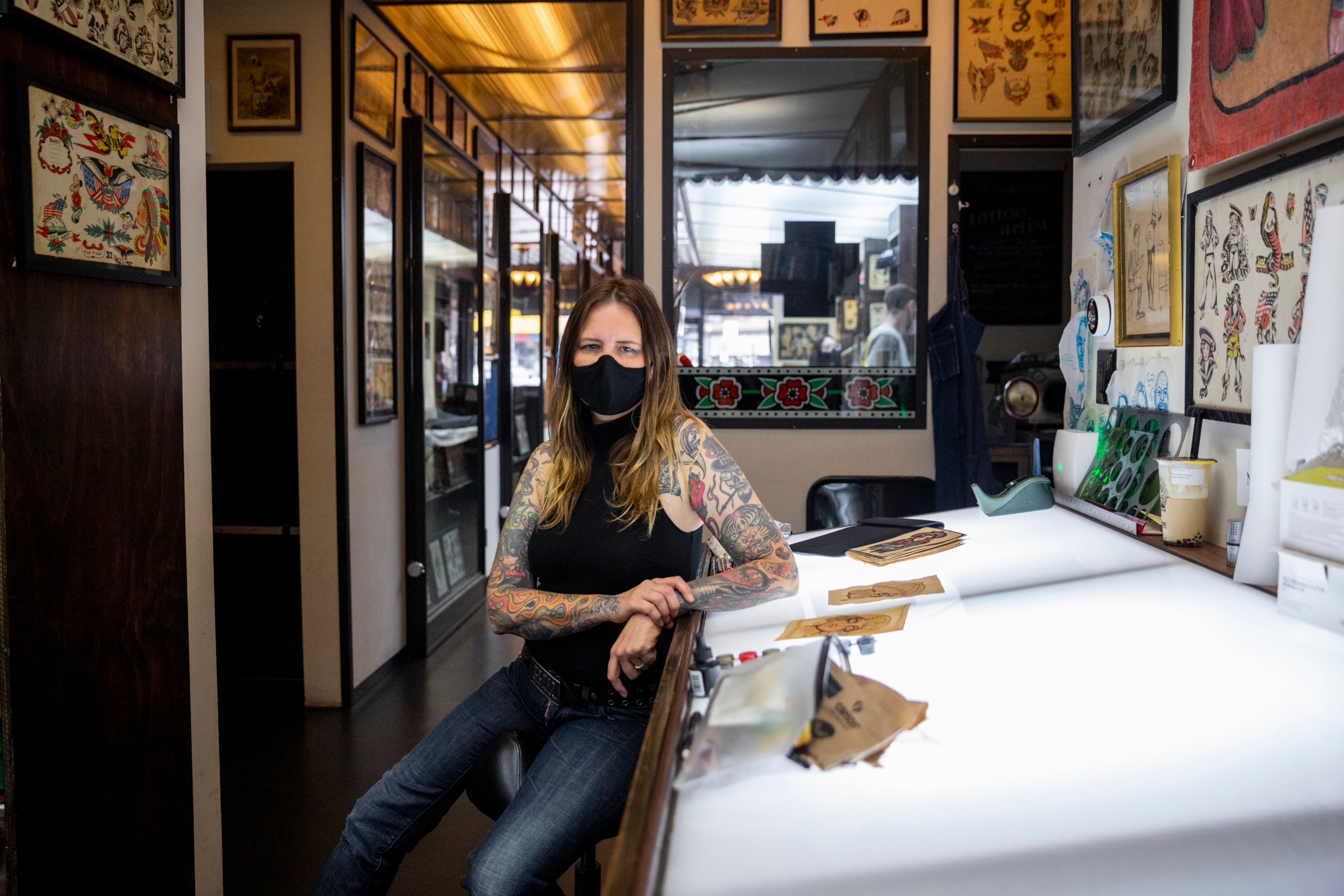 Michelle Myles, a co-owner of Daredevil Tattoo, sits inside her shop