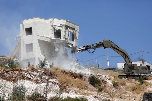 An Israeli army excavator machine demolishes a building in the Palestinian village of Sur Baher, in East Jerusalem (EPA/ABED AL HASHLAMOUN)