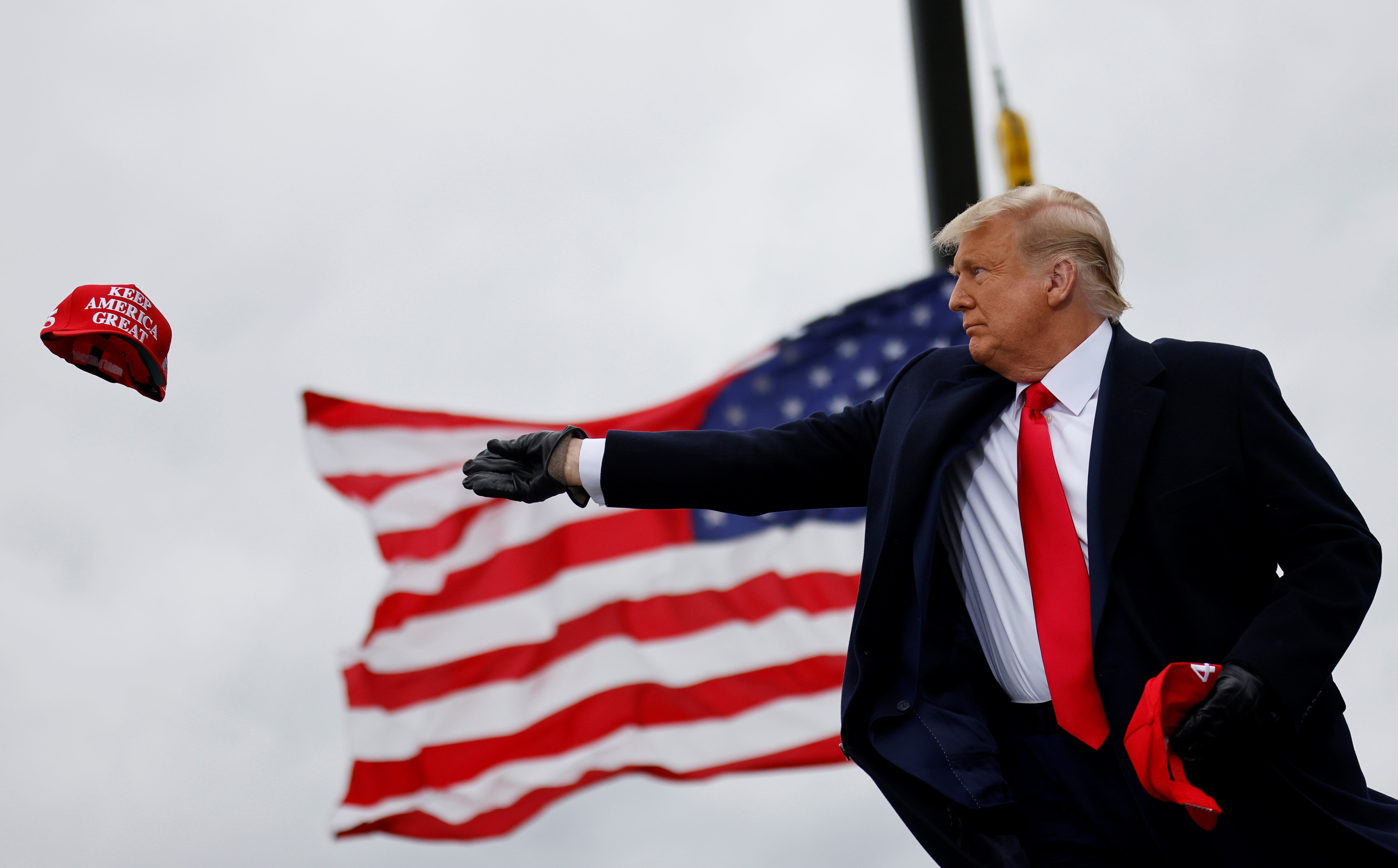 <p>President Donald Trump tosses out Make America Great Again (MAGA) caps as he arrives for a campaign rally in Michigan. REUTERS/Carlos Barria</p>