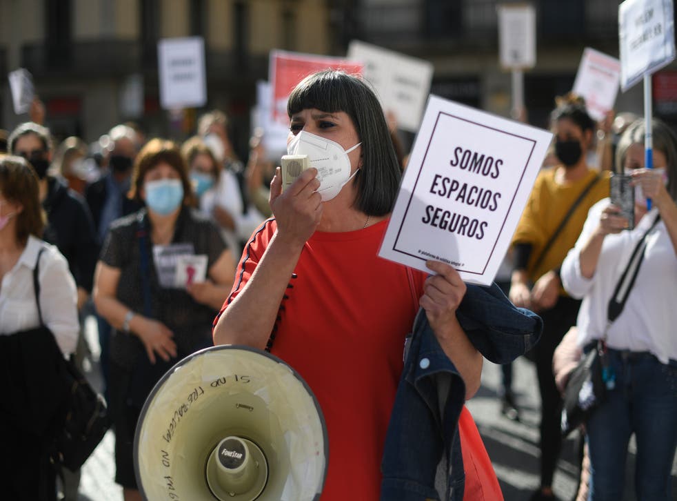 <p>A protester holds a sign reading ‘We are safe spaces’ during a demonstration in Barcelona by restaurant and bar owners to protest against closures&nbsp;</p>