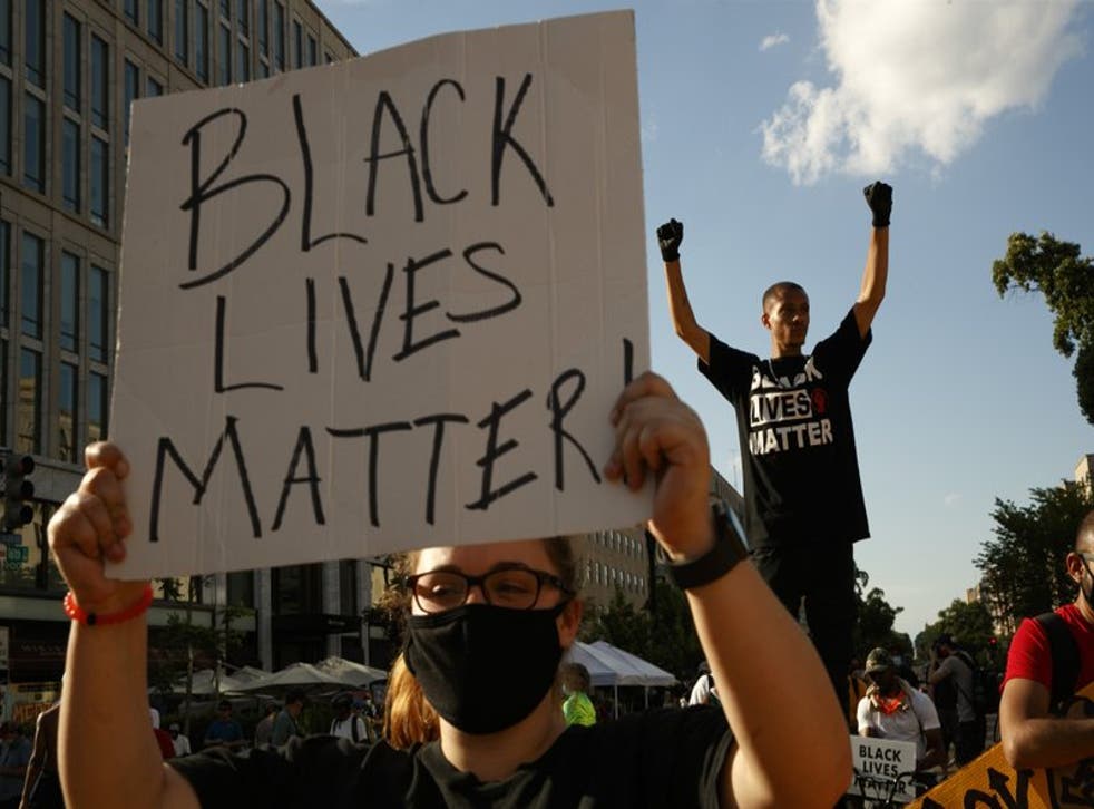 Manifestantes protestan frente a una hilera de policías en Washington.