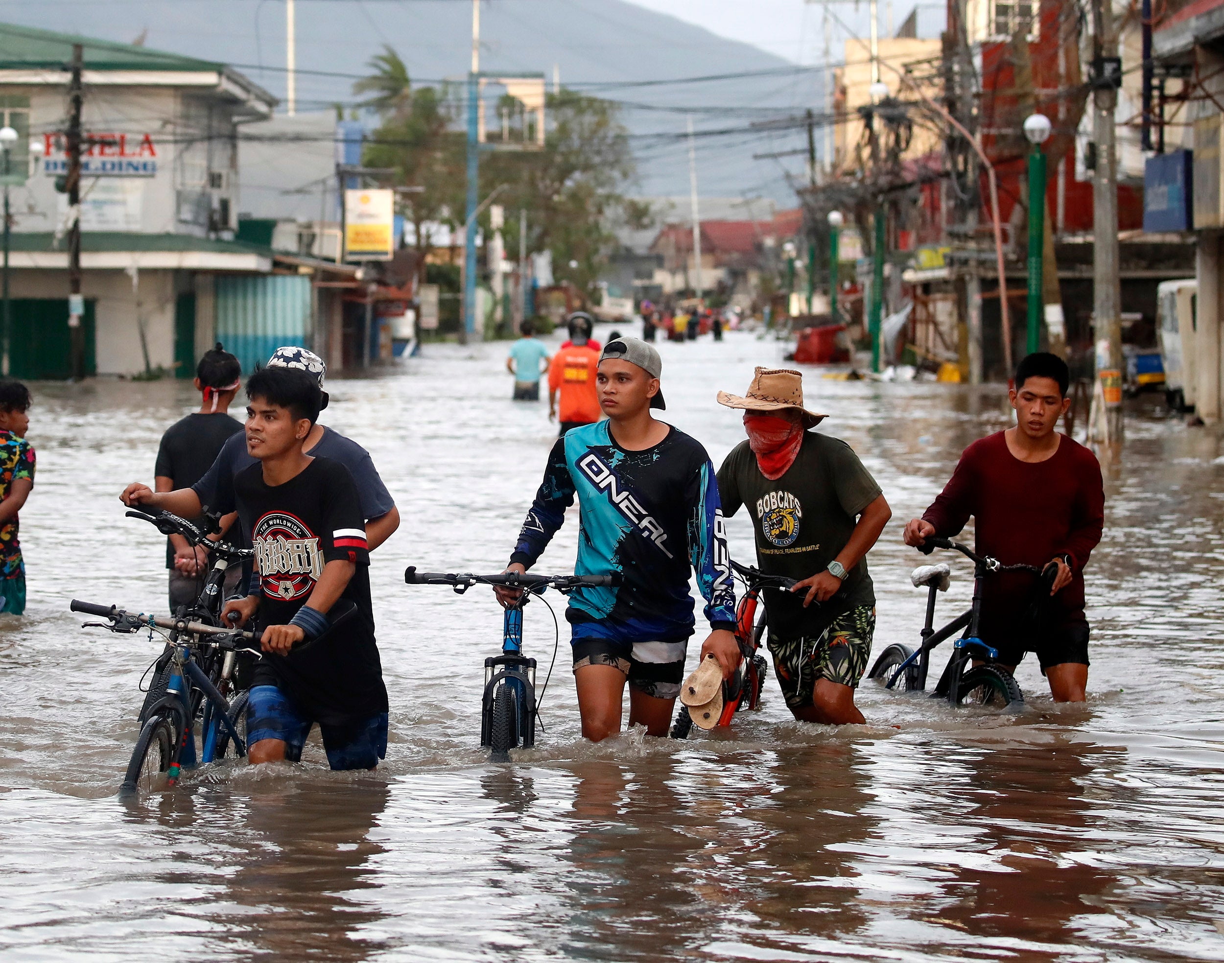 Filipino villagers wade along a flooded road in the typhoon-hit town of Nabua, Camarines Sur, Philippines