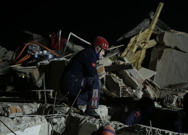 Un miembro de los servicios de rescate se arrodilla para escuchar durante la búsqueda de sobrevivientes entre los restos de un edificio en Izmir, Turquía, el sábado 31 de octubre de 2020. Un fuerte sismo registrado el viernes en el Mar Egeo entre la costa turca y la isla griega de Samos dejó varios muerto y cientos de heridos. (Foto/Emrah Gurel)