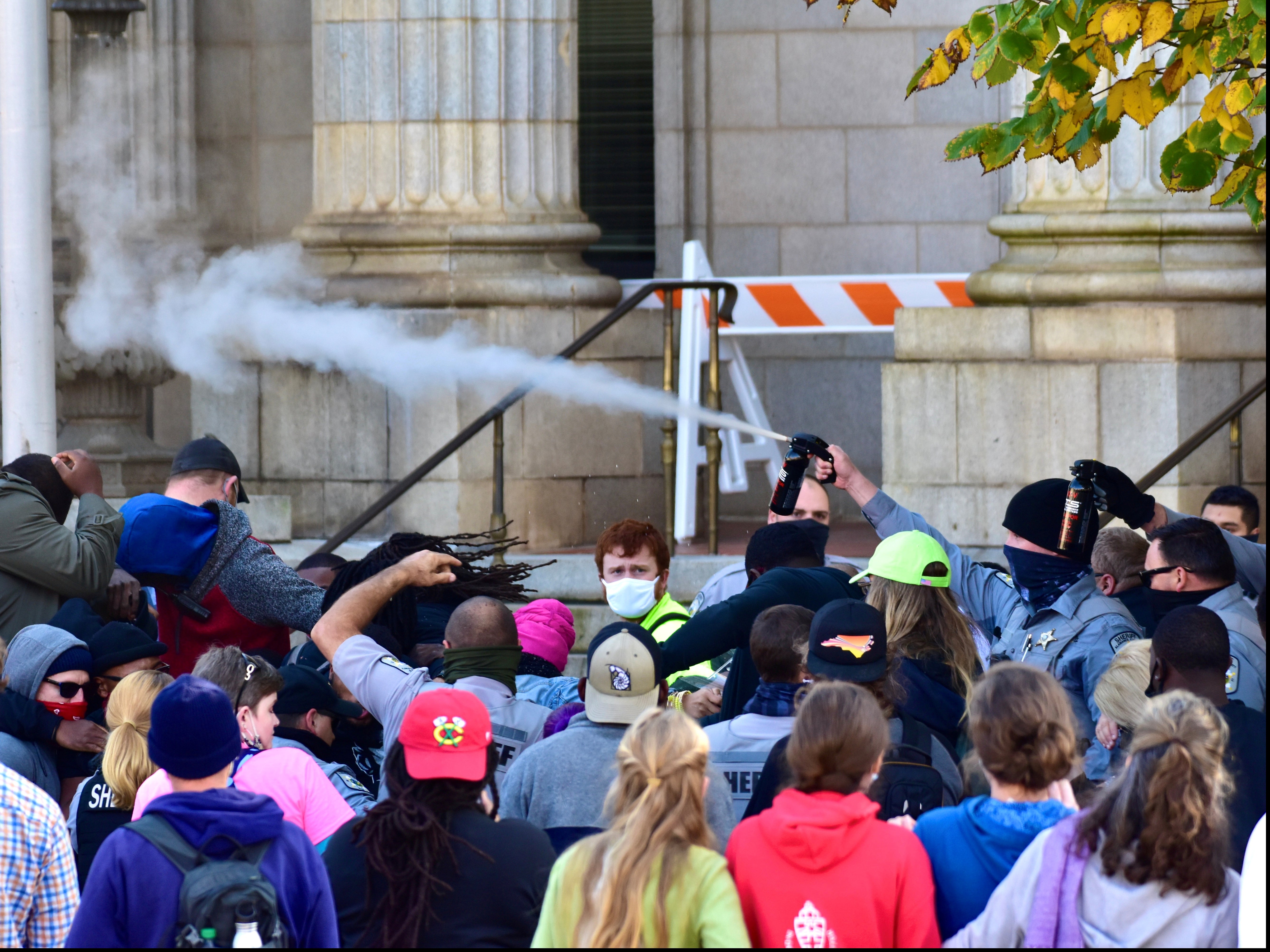 Law enforcement officers spray protesters shortly after a moment of silence in Graham, North Carolina.