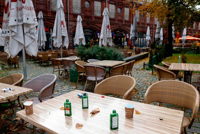 <p>The remains of the last party are seen on the table of a closed cafe at Berlin's Hackescher Markt</p>