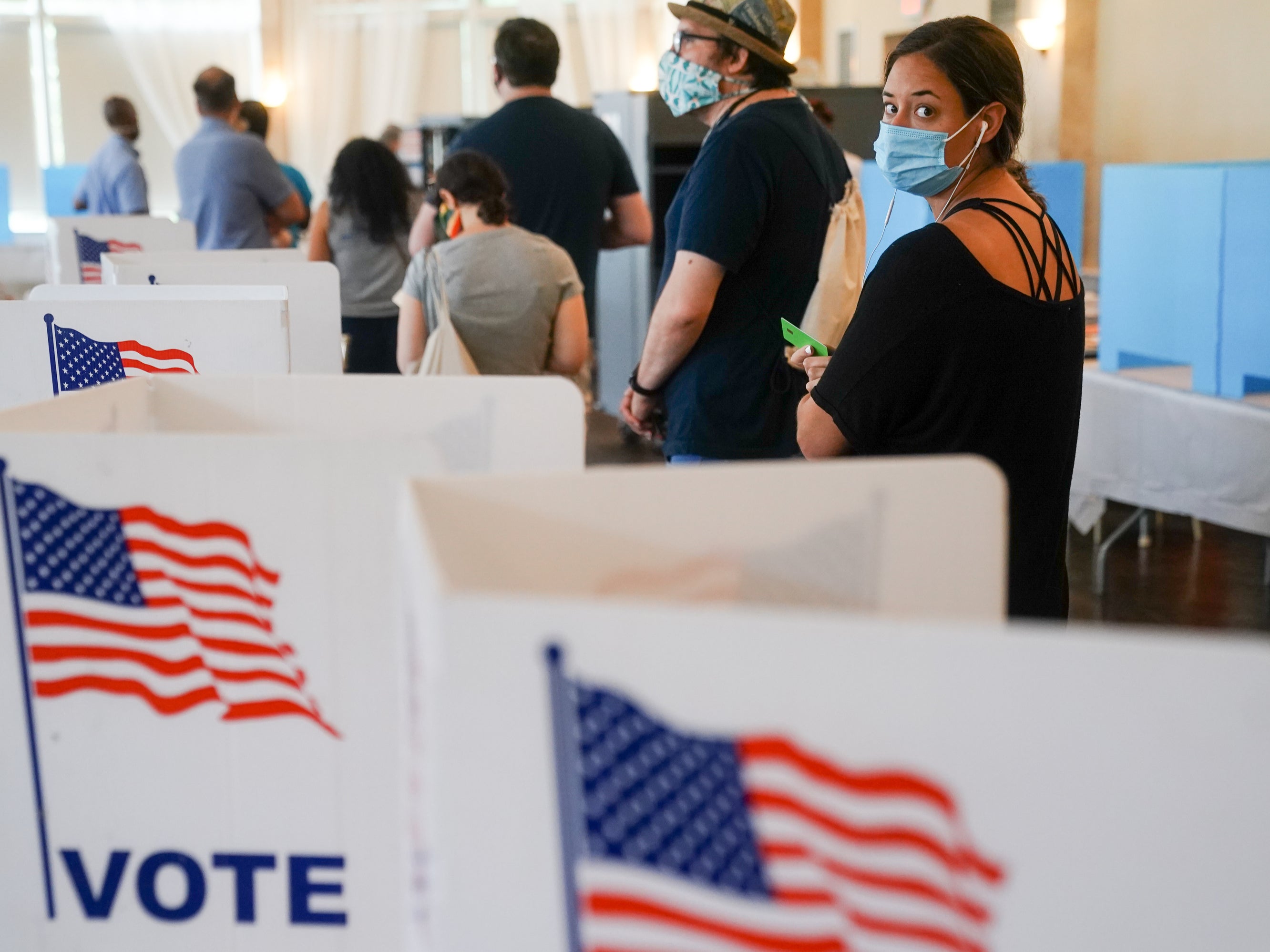 People wearing face masks wait in line to vote in Georgia’s Primary Election 