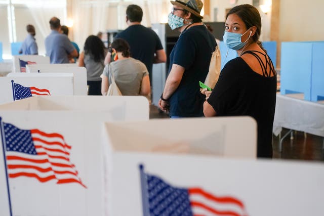 People wearing face masks wait in line to vote in Georgia’s Primary Election 