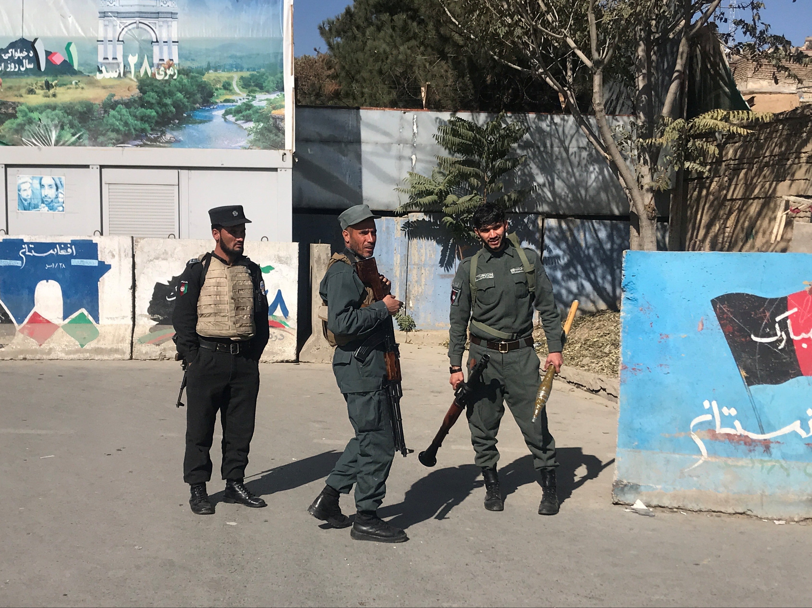 Afghan policemen keep watch near the site of an attack at Kabul University