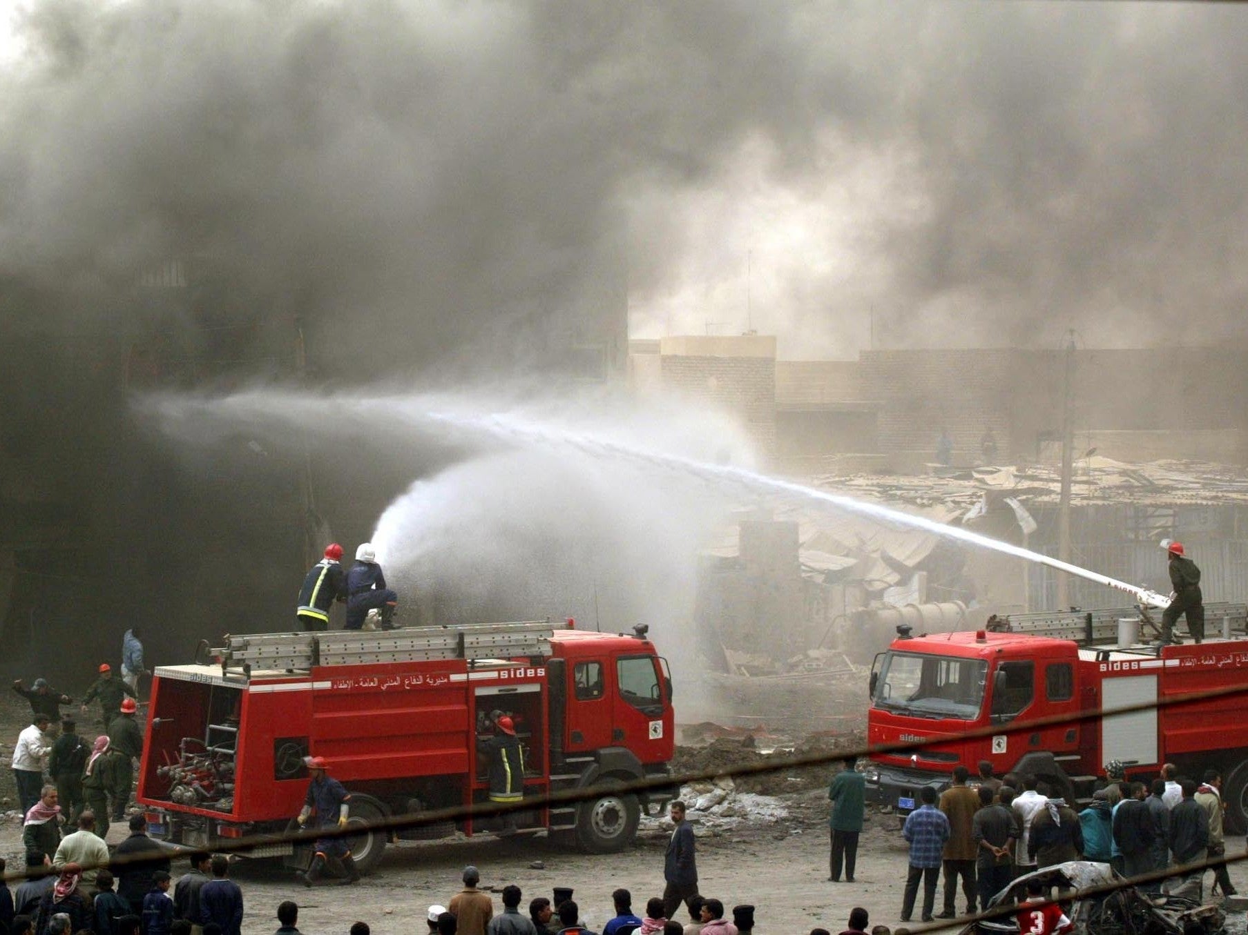 Iraqi firefighters tackle a burning building after the airstrike in Baghdad