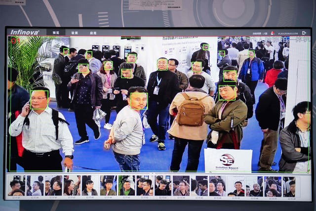 Una pantalla muestra a los visitantes siendo filmados por cámaras de seguridad de IA (inteligencia artificial) con tecnología de reconocimiento facial en la 14a Exposición Internacional de China sobre Seguridad Pública en el Centro Internacional de Exposiciones de China en Beijing el 24 de octubre de 2018. (Foto de NICOLAS ASFOURI / AFP ) (Foto de NICOLAS ASFOURI/AFP vía Getty Images)