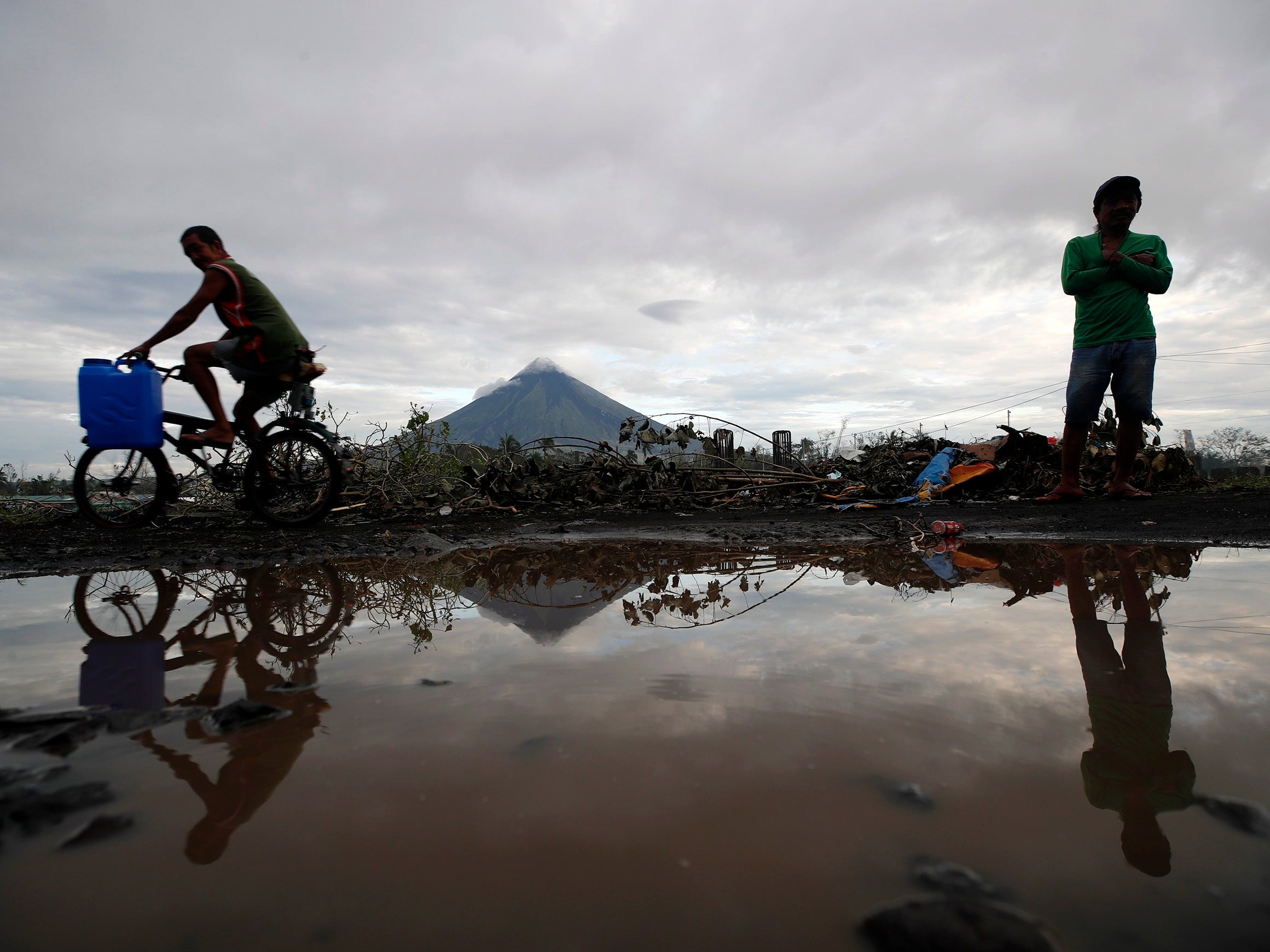 Villagers wade on flood water brought by a lahar flow due to typhoon Goni at the foot of Mayon volcano in The Philippines