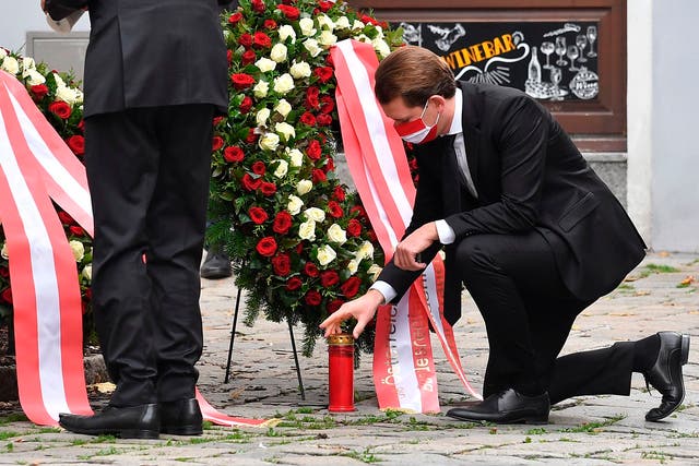 Sebastian Kurz places a candle at a crime scene as he pays his respects to the victims of a shooting in Vienna