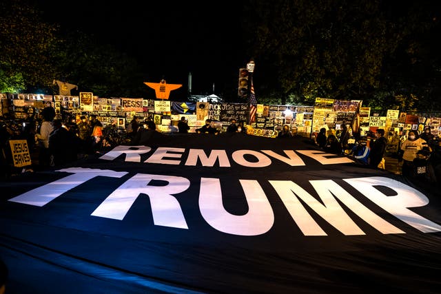 Protestors unfurl a banner that says "Remove Trump" on Black Lives Matter Plaza in front of the White House on Election Day