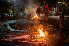 Protesters set American flags on fire as US election results roll in