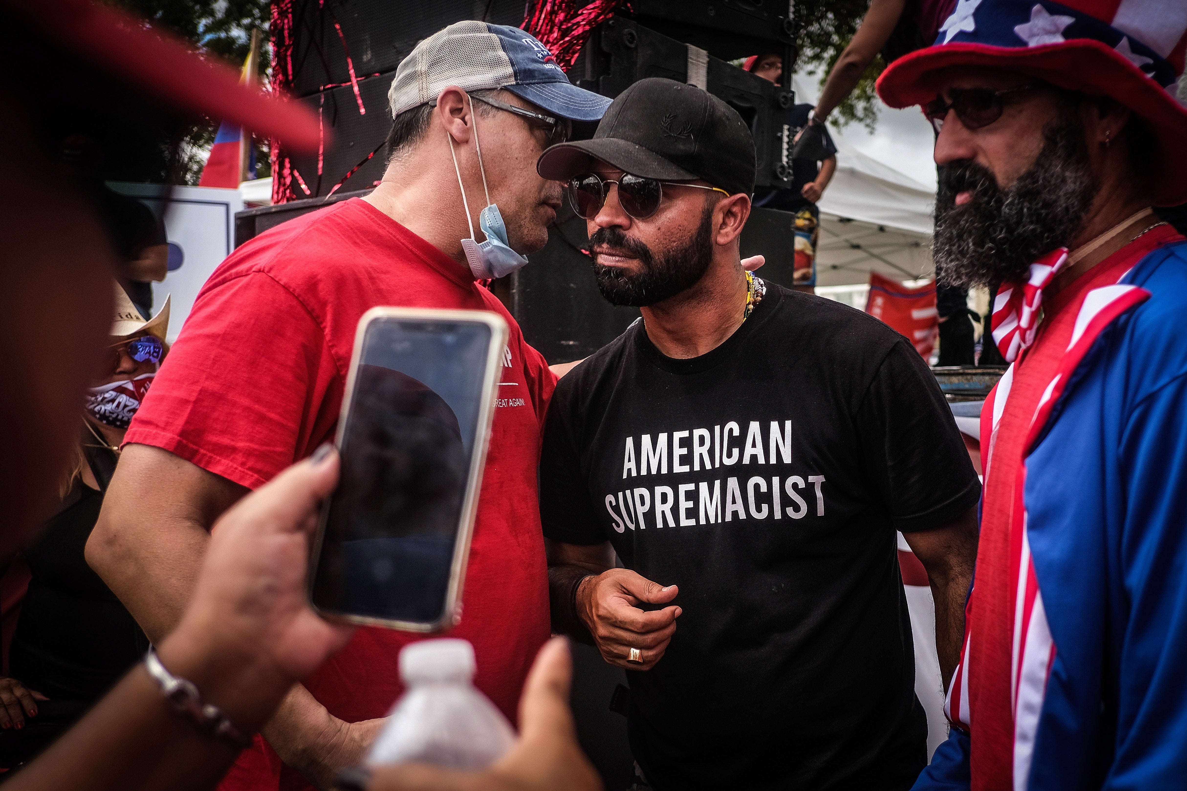 <p>Enrique Tarrio (C), chairman of the Proud Boys, interacts with supporters during the 'Latinos for Trump' demonstration in Miami on 18 October</p>