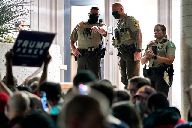 Maricopa County Sheriff's Deputies stand at the door of the Maricopa County Recorder's Office as President Donald Trump supporters rally outside, Wednesday, Nov. 4, 2020, in Phoenix. (AP Photo/Matt York)