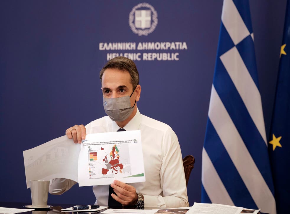 <p>Greece’s prime minister Kyriakos Mitsotakis shows a map of Europe during his announcement on the country’s new lockdown</p>