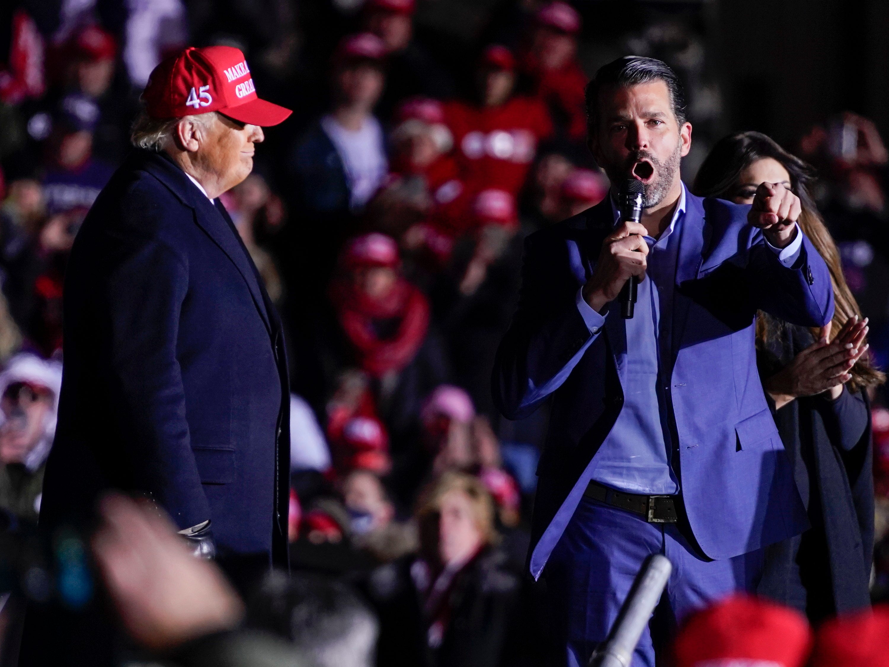 <p>The US president listens as Donald Trump Jr speaks during a campaign rally at Kenosha regional airport</p>