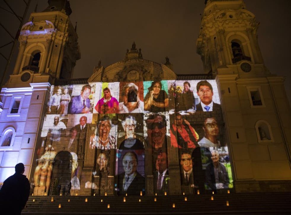 Víctimas del COVID-19 proyectados en la fachada de la Catedral de Lima antes del inicio de una misa dedicada a los más de 30.000 fallecidos en Perú.
