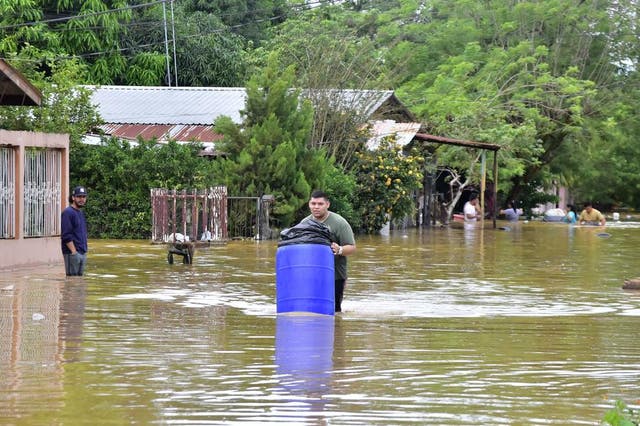 People try to save their belongings while leaving their homes after flooding due to Storm Eta, in El Progreso, Honduras