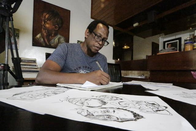 El dibujante y comentarista keniano Patrick Gathara, dibuja cartones en su casa de Nairobi, Kenia.