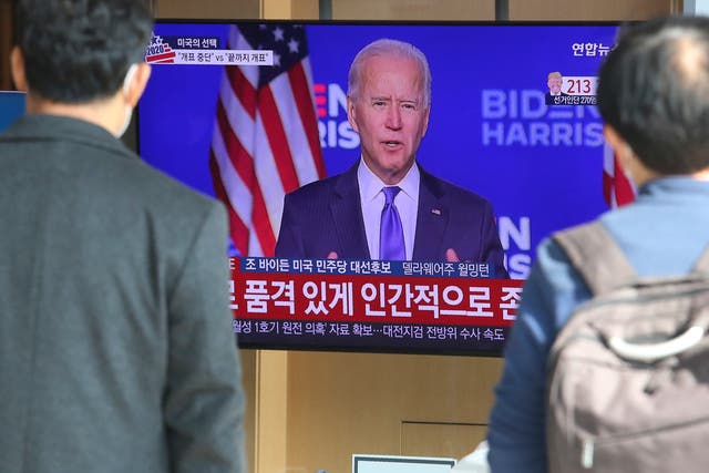 People watch a TV screen showing Joe Biden at the Seoul Railway Station in Seoul, South Korea, Saturday, Nov. 7, 2020. (AP Photo/Ahn Young-joon)