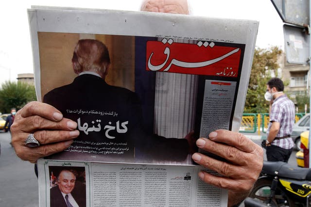 <p>A man reads a copy of Iranian daily newspaper ‘Shargh’ with a picture of outgoing US president Donald Trump</p>