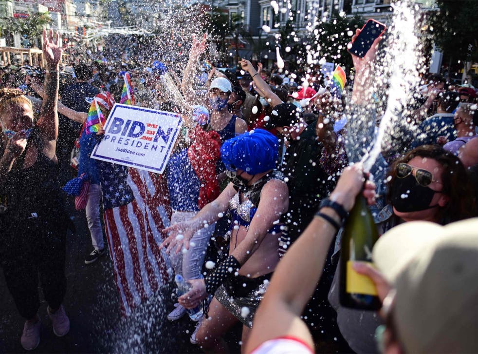 People spraying champagne in the street and dancing in celebration for Joe Biden getting elected President of the United States in the Castro district of San Francisco, California, 7 November