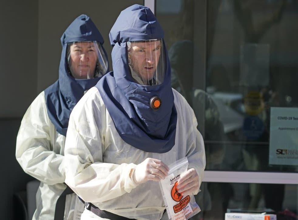En esta fotografía del 3 de noviembre de 2020, enfermeros del Departamento de Salud del condado Salt Lake caminan en un sitio de pruebas de coronavirus afuera de la agencia en Salt Lake City.