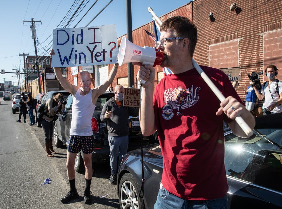 Trump and Biden supporters outside a press conference where Rudy Giuliani spoke to the media in the back parking lot of landscaping company on November 7, 2020 in Philadelphia, Pennsylvania (Photo by Chris McGrath/Getty Images)