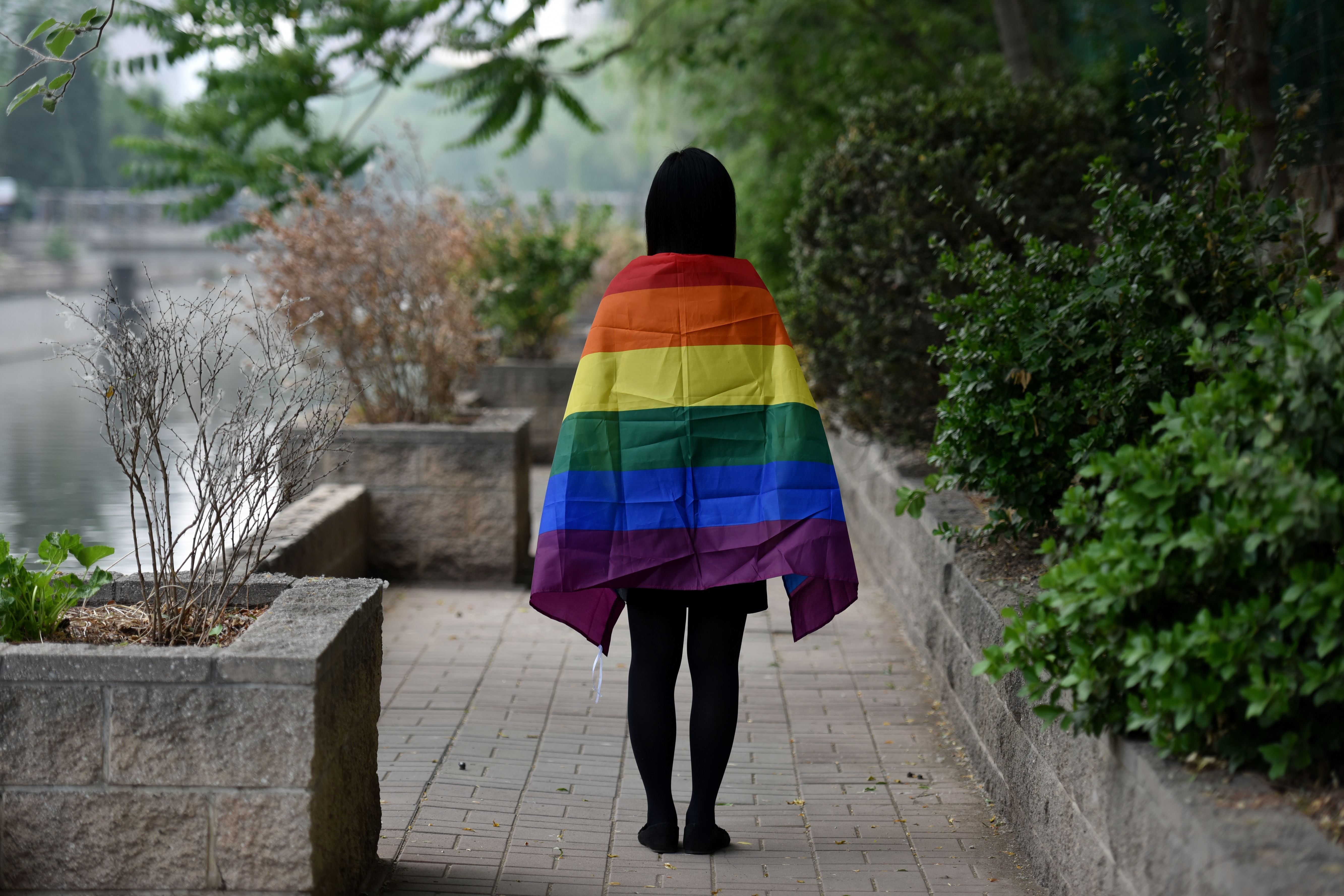 An LGBT student poses with a rainbow flag in Beijing