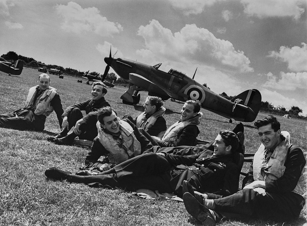 Pilots relax on the grass beside their Hawker Hurricane Mk1 fighters on 29 July 1940 at RAF Hawkinge