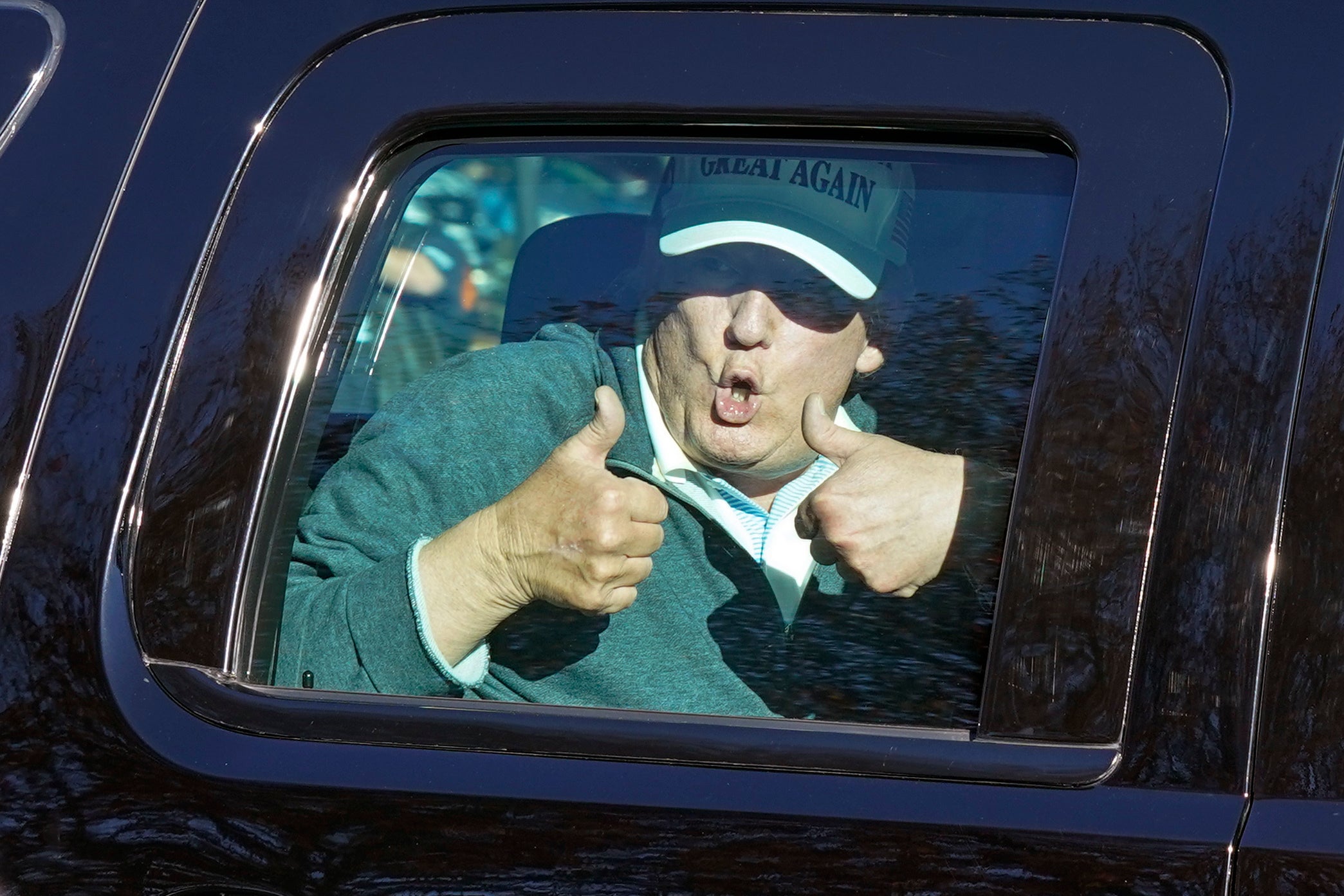 Trump gives two thumbs up to supporters as he departs after playing golf at the Trump National Golf Club the day after Biden is announced as the winner of US election