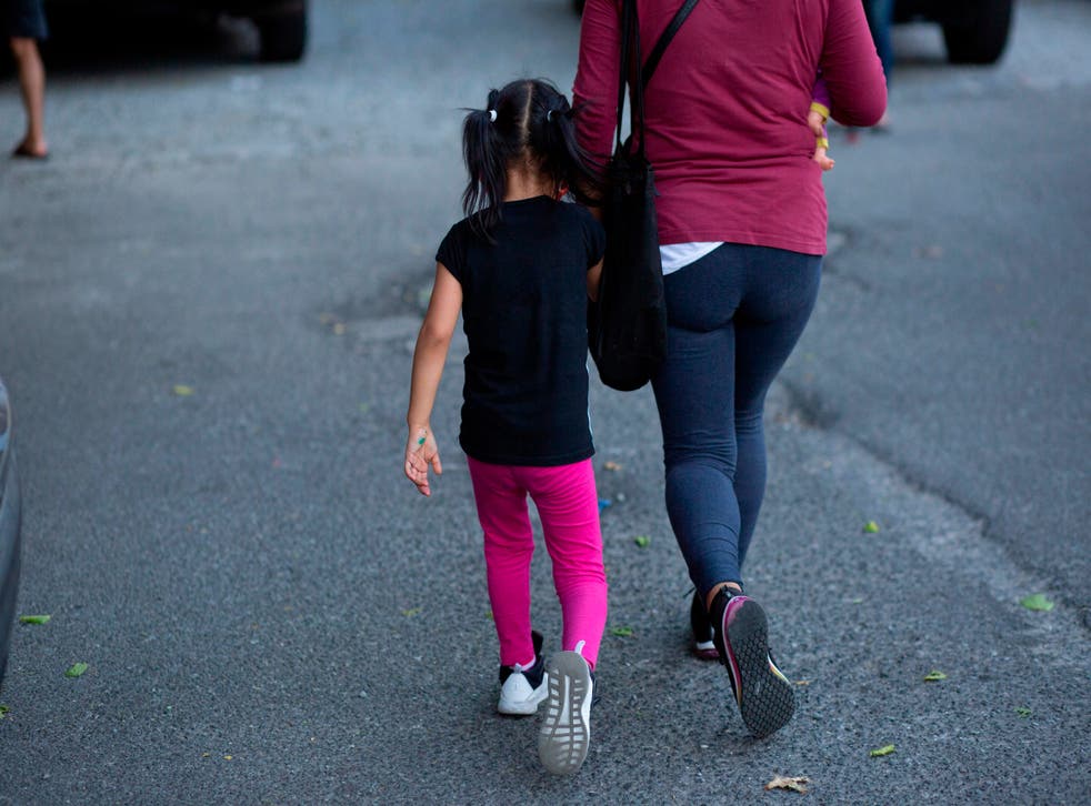 Betty from Ecuador, and her 4 year-old daughter arrive to a food distribution center in Queens on August 25, 2020 in New York City. - As the first day of school approaches, New York’s poorest -- often uninsured families -- face a risky choice: send kids to school where they could contract coronavirus, or keep them home for online classes, potentially compromising their academic progress and preventing parents from working.