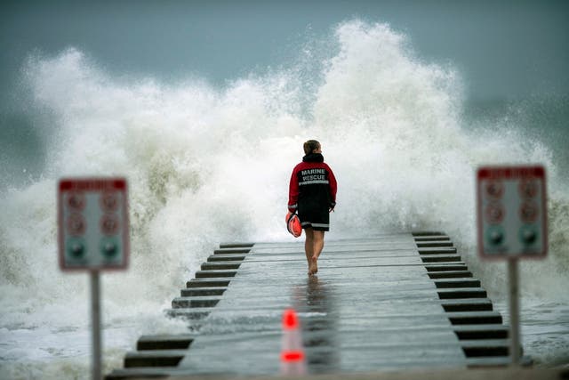 A lifeguard walks to the end of the jetty after closing it down to surfers before the arrival of Tropical Storm Eta in Bradenton Beach, Florida