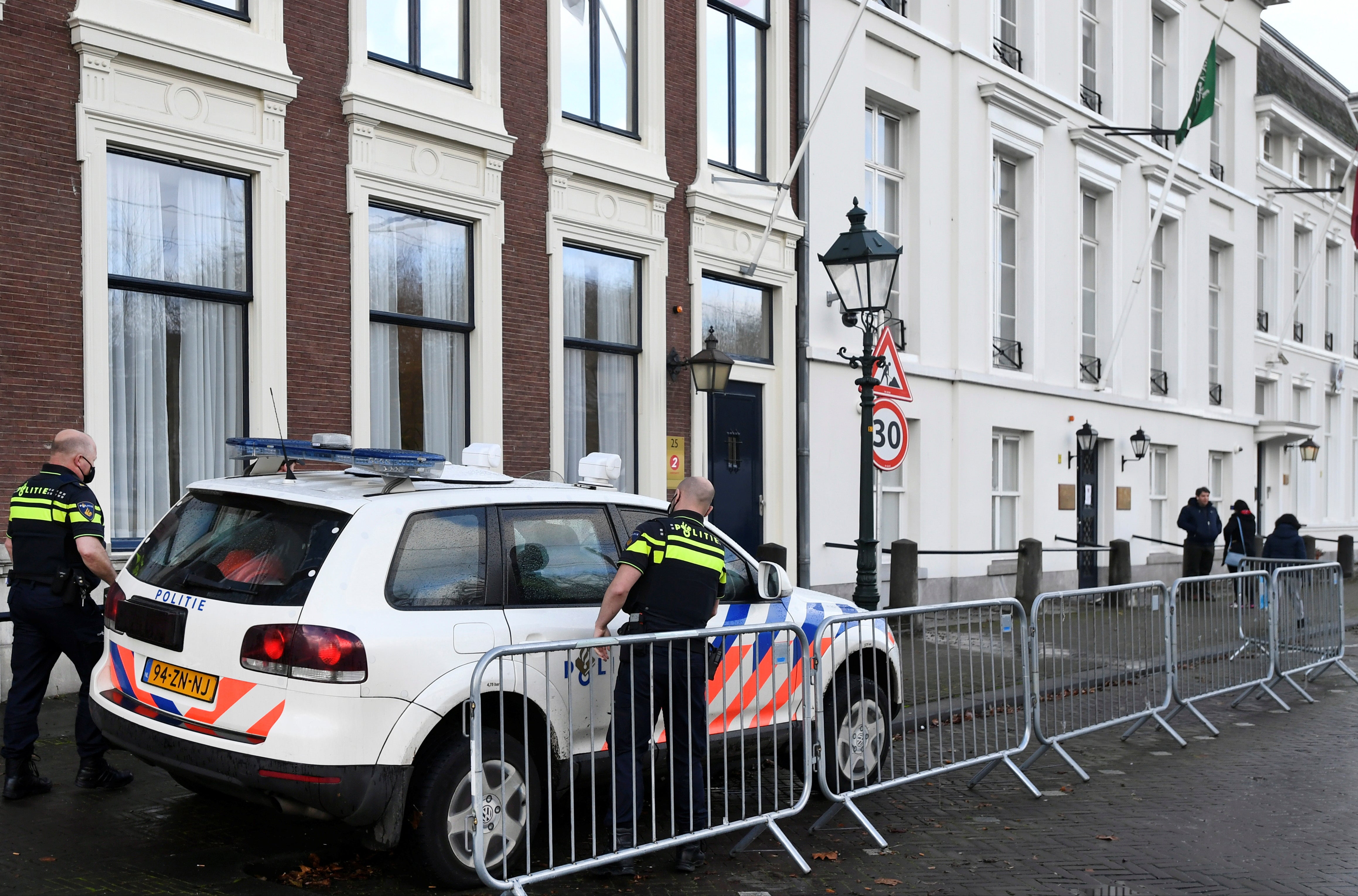 Police officers stand near the Embassy of Saudi Arabia after unidentified assailants sprayed it with gunfire, in The Hague, Netherlands
