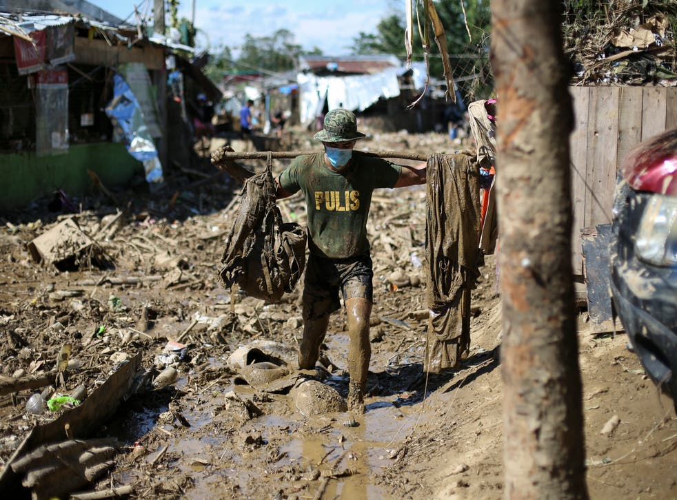 <p>A man works in the aftermath of a typhoon in the Philippines</p>