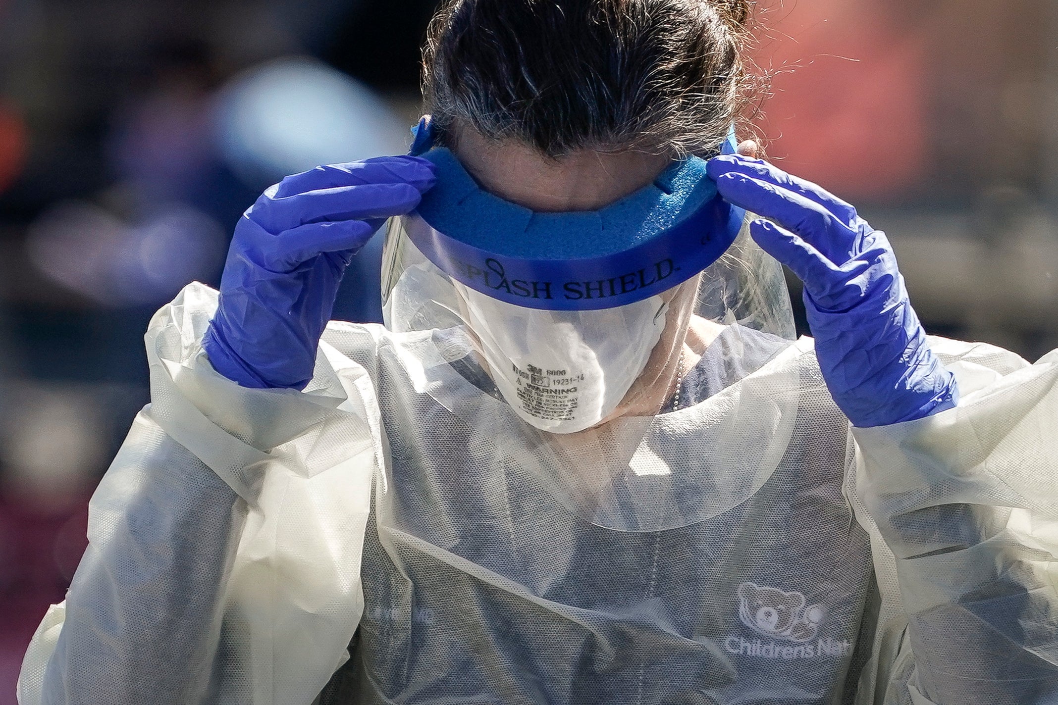 A medical professional from Children’s National Hospital works at a coronavirus drive-thru testing site for children age 22 and under at Trinity University on 2 April, 2020 in Washington, DC.