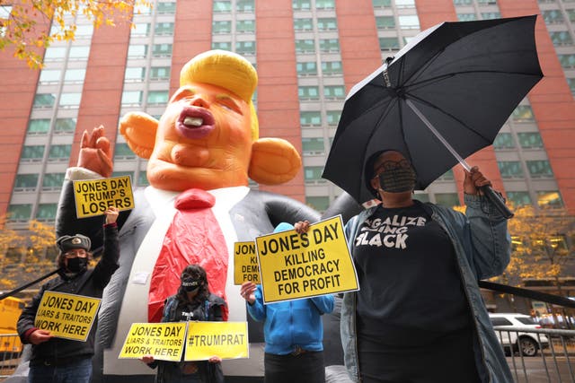 Demonstrators hold up signs in front of an inflatable giant rat in the likeness of U. S. President Donald Trump outside the NYC office of Jones Day law Firm on November 13, 2020 in New York City. The Jones Day Law firm is representing U.S. President Donald Trump and the Republican party in challenging the results of the 2020 presidential elections.   (Photo by Michael M. Santiago/Getty Images)