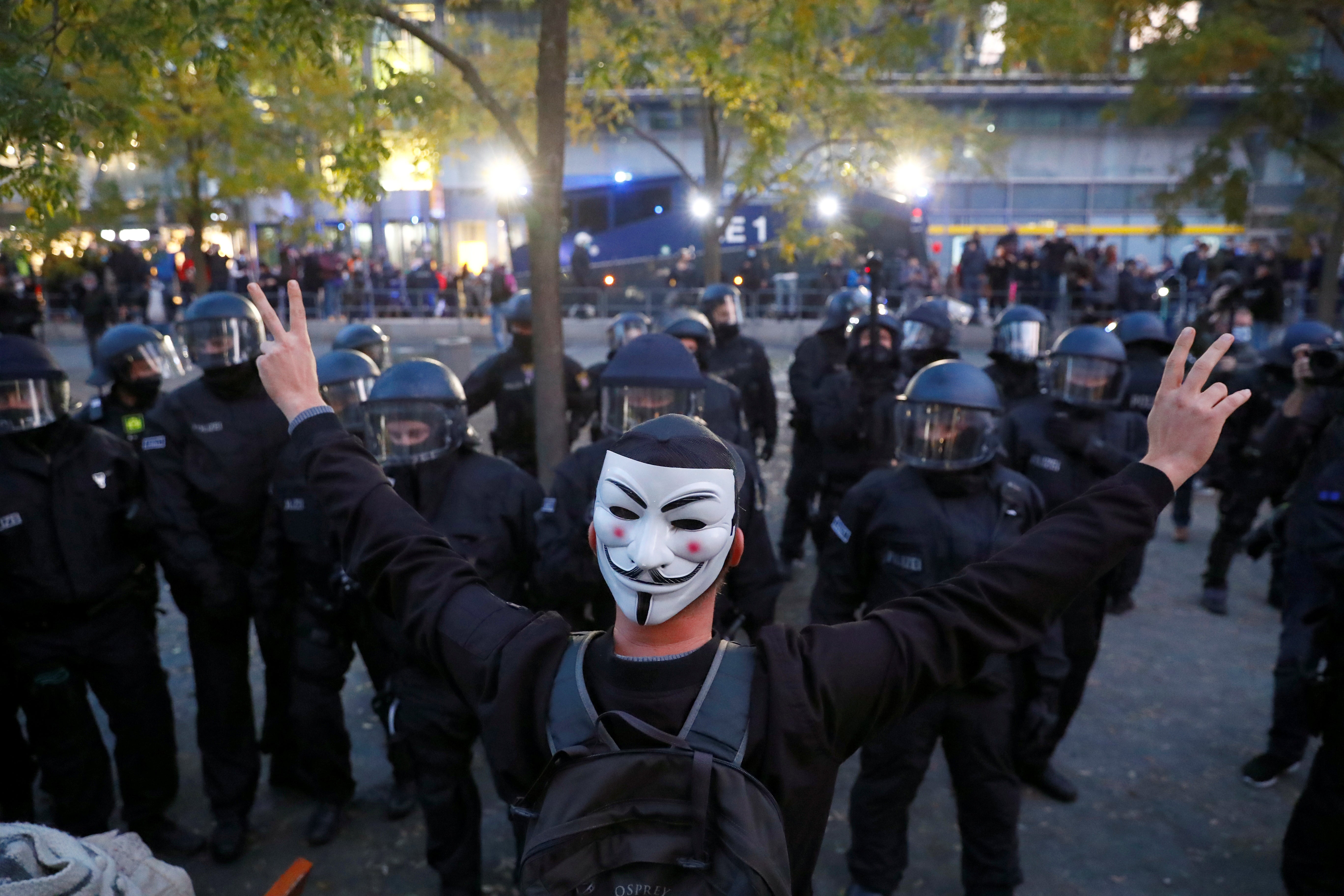 A demonstrator gestures in front of police during a protest against the government's restrictions following the coronavirus disease (COVID-19) outbreak