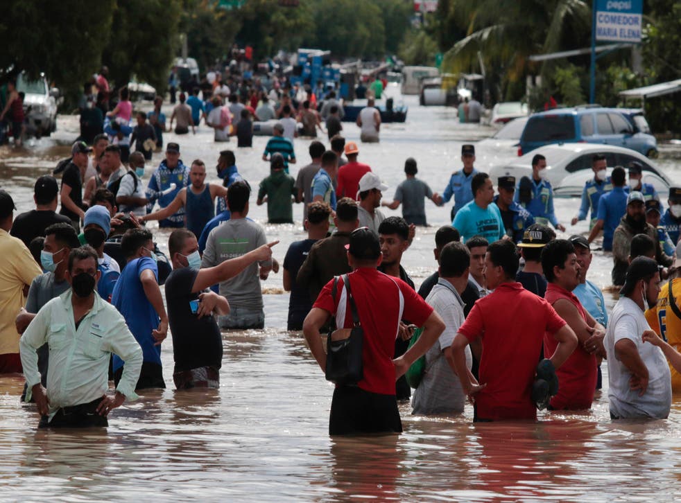 <p>Múltiples personas vadean un camino inundado el jueves 5 de noviembre de 2020 tras el paso del huracán Eta, en Planeta, Honduras.</p>