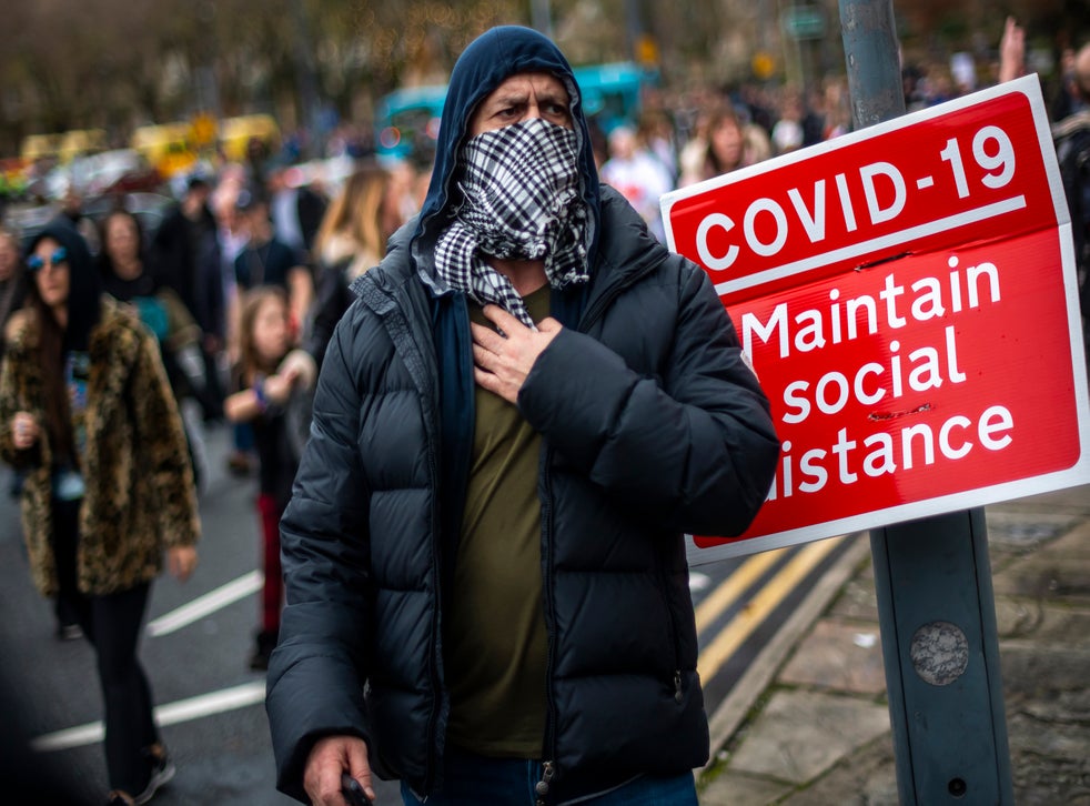 <p>A man wears a scarf as a face covering during an anti-lockdown protest in Liverpool on Saturday</p>