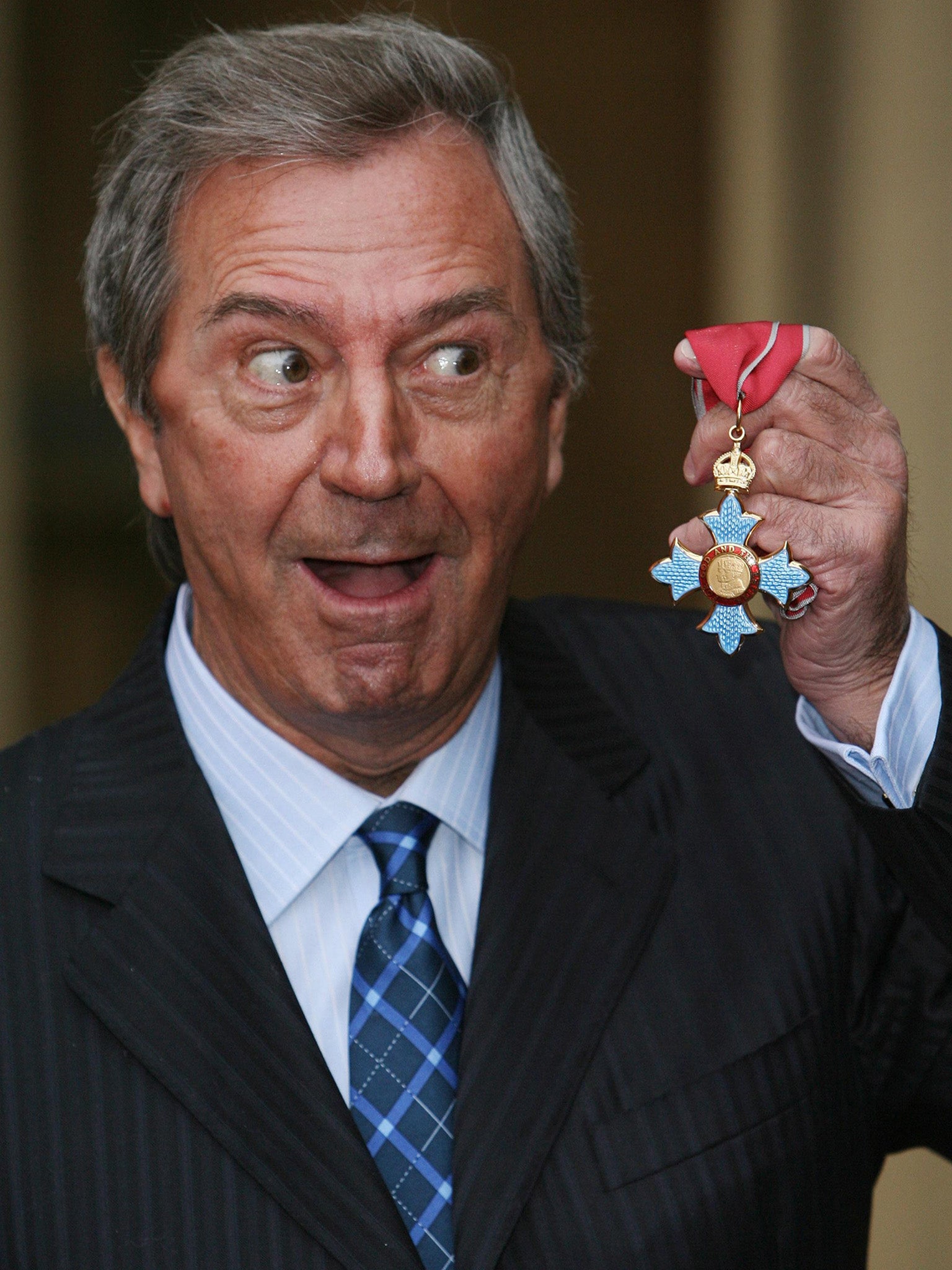 The entertainer poses with his CBE at Buckingham Palace in 2008