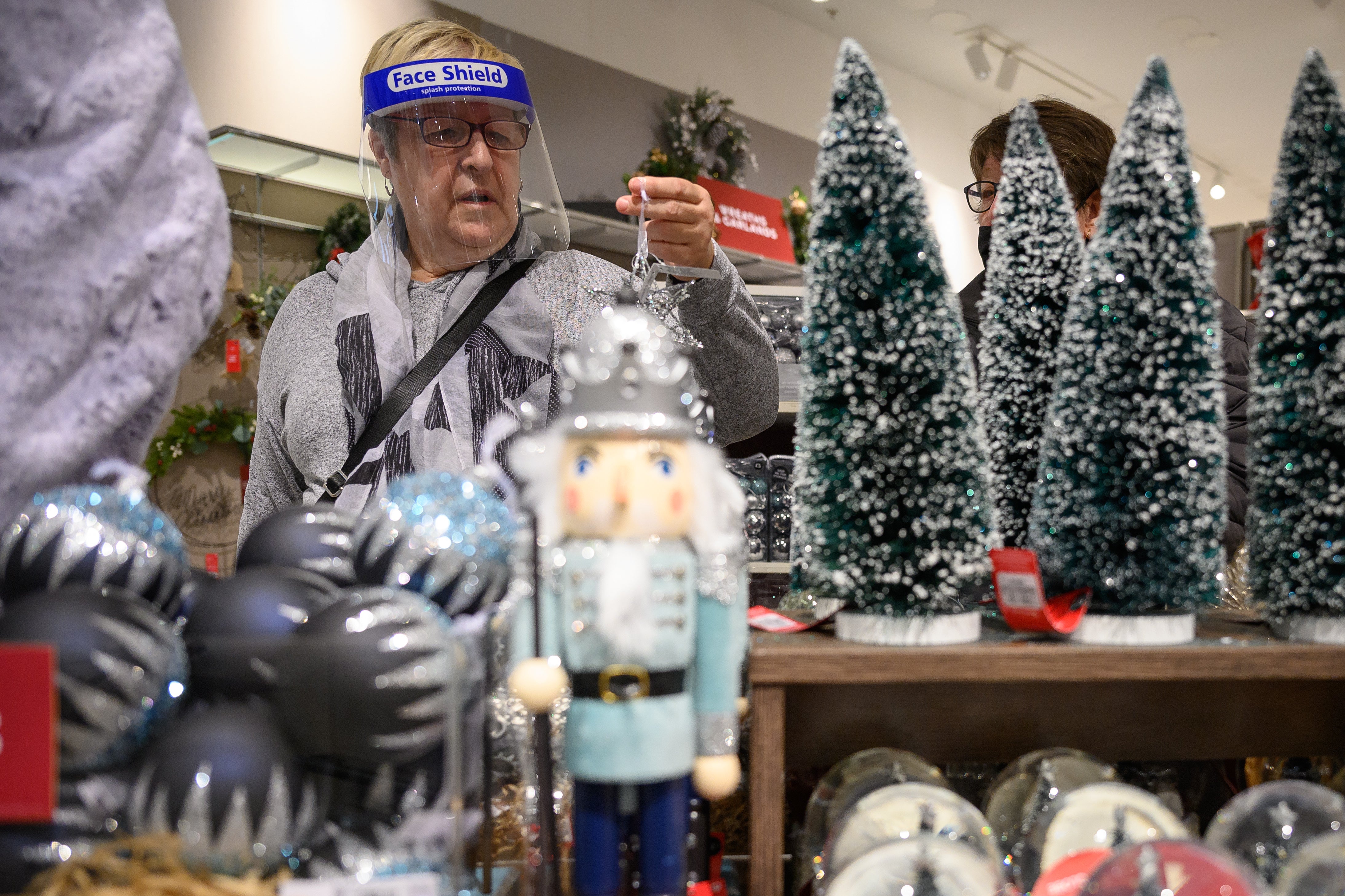 A customer browses some of the festive items in the Christmas gift and decoration section