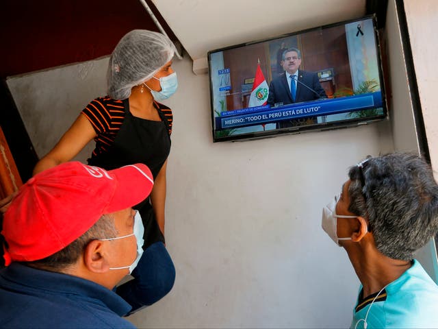 <p>People in a snack bar in Lima watch as Peruvian interim president Manuel Merino announces he is standing down in a televised message on Sunday</p>