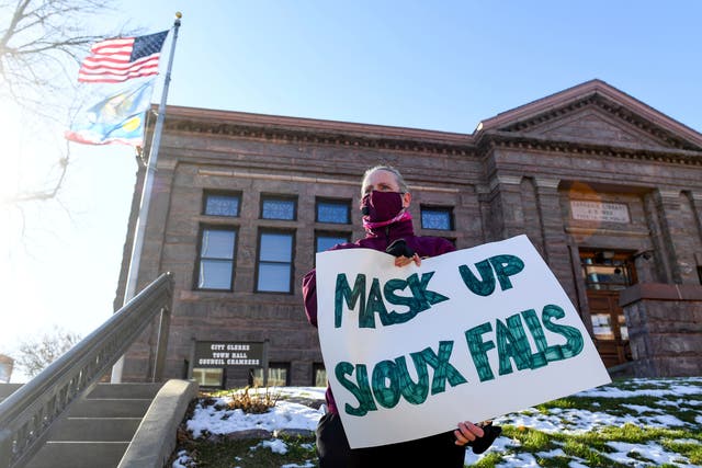 <p>Jenae Ruesink holds a sign demanding a mask mandate from city council on Monday, Nov. 16, 2020 outside Carnegie Town Hall in Sioux Falls, S.D. (Erin Bormett/The Argus Leader via AP)</p>