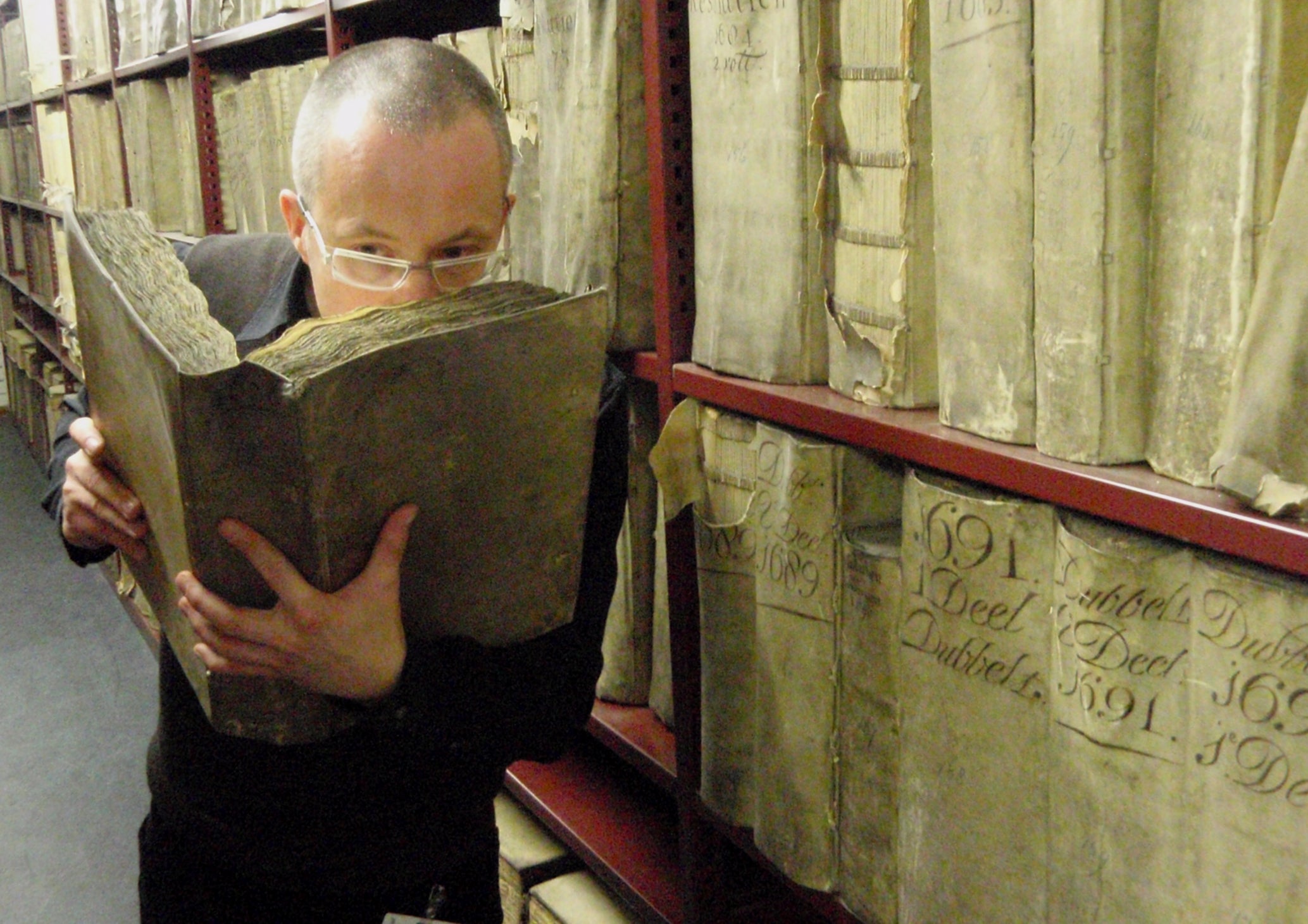 Prof Matija Strlic smelling a historic book in the National Archives of The Netherlands