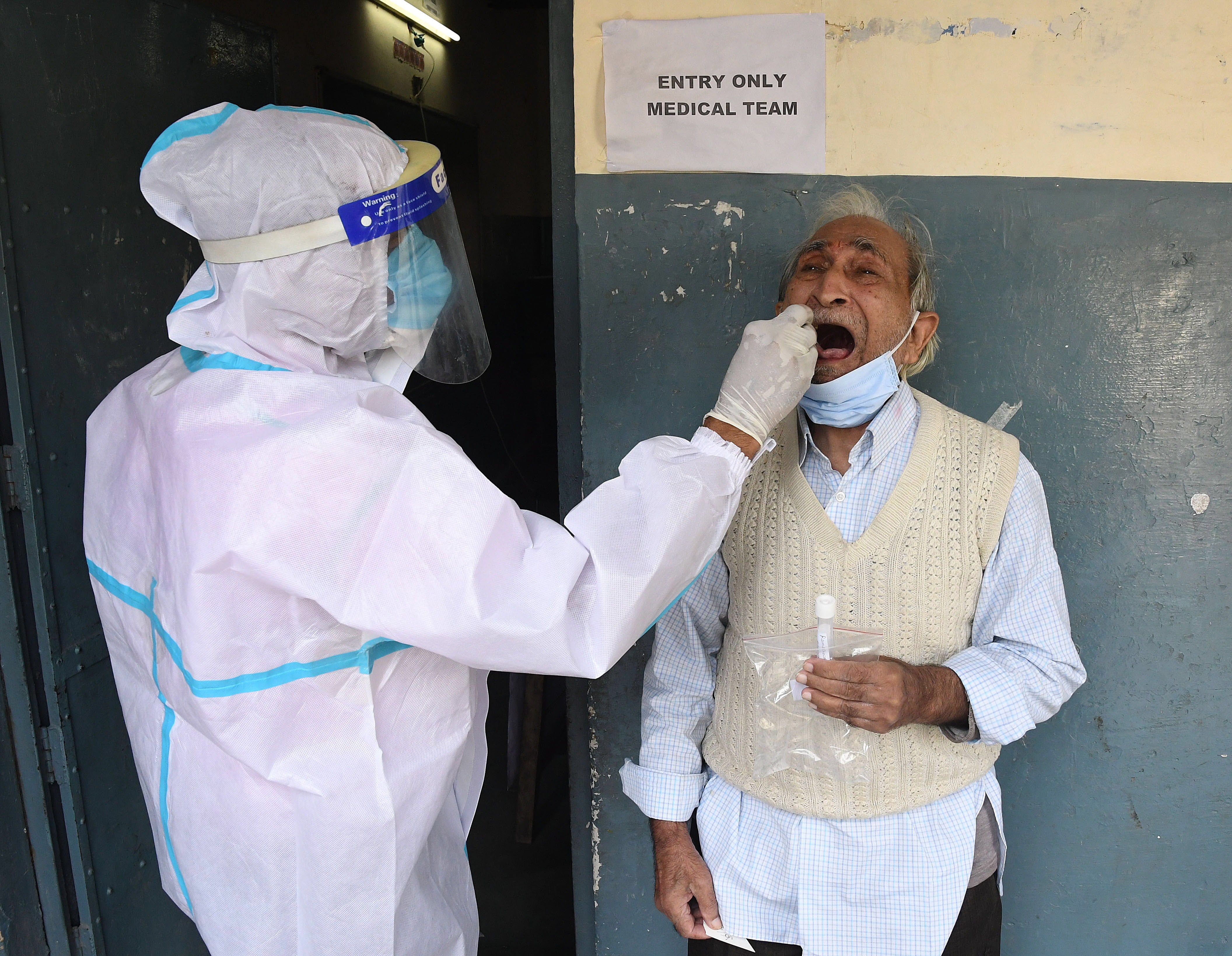 A health official collects swab sample during Covid-19 rapid test in Delhi on Tuesday