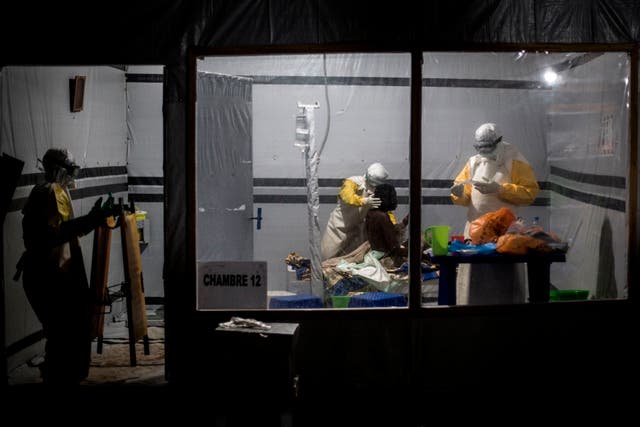 Health workers treat an unconfirmed Ebola patient