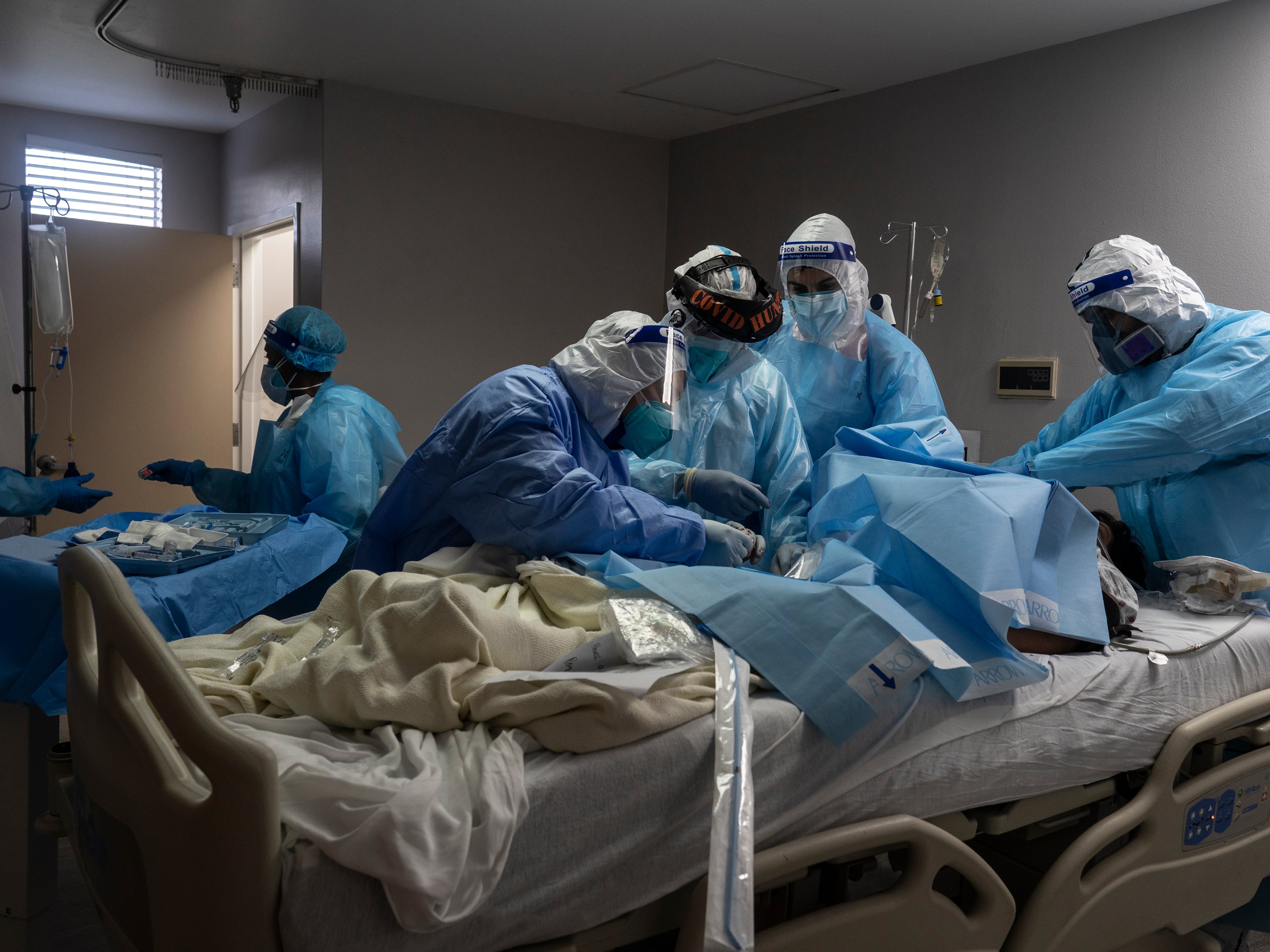Medical staff members treat a patient suffering from coronavirus in the COVID-19 intensive care unit (ICU) at the United Memorial Medical Center (UMMC) in Houston, Texas